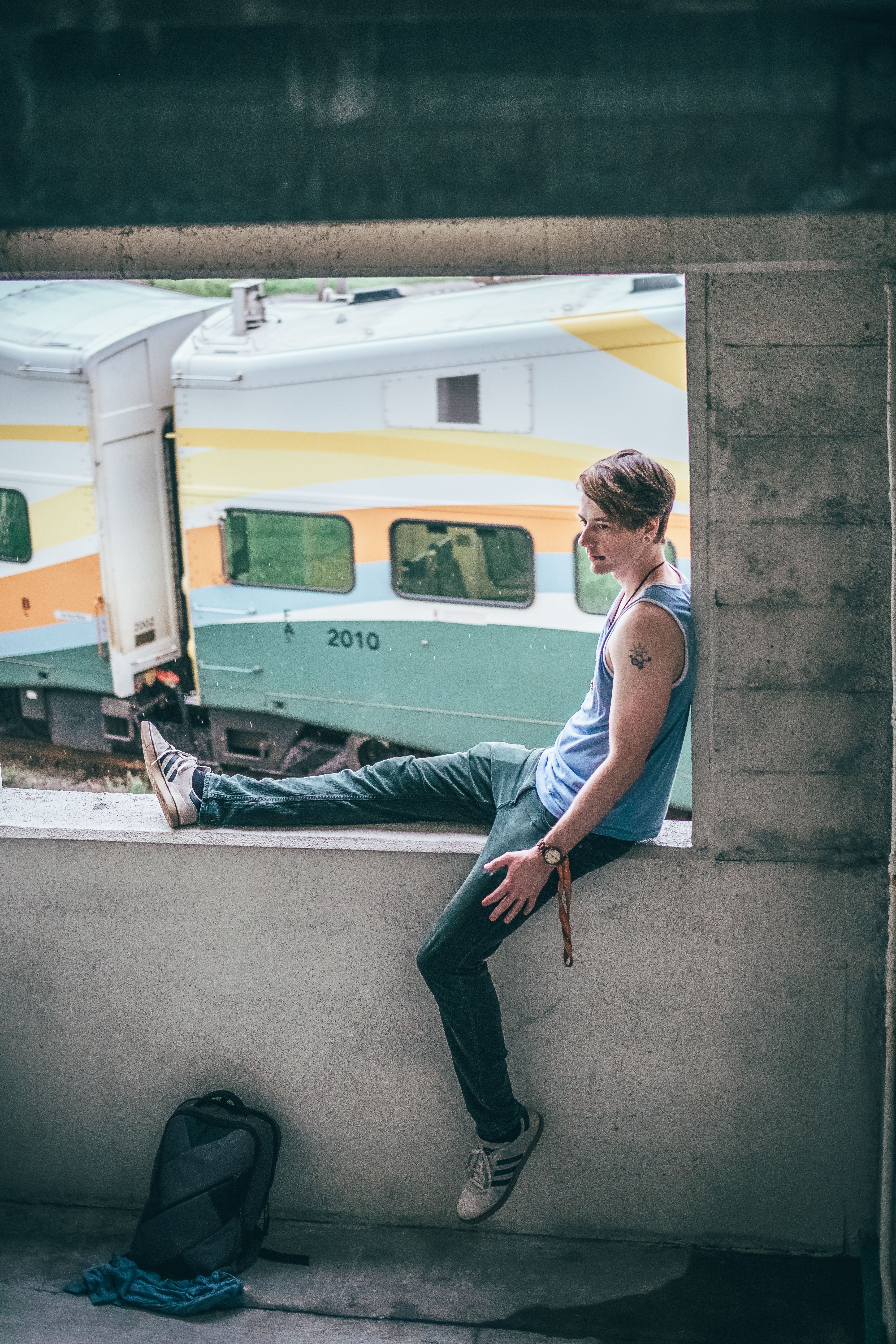 Candid shot of a man sitting on a windowsill overlooking a moving train.