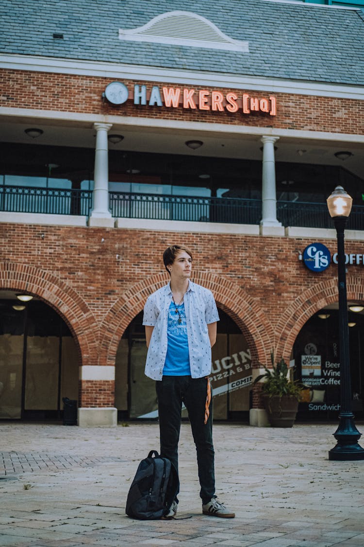 A Man Standing With A Backpack