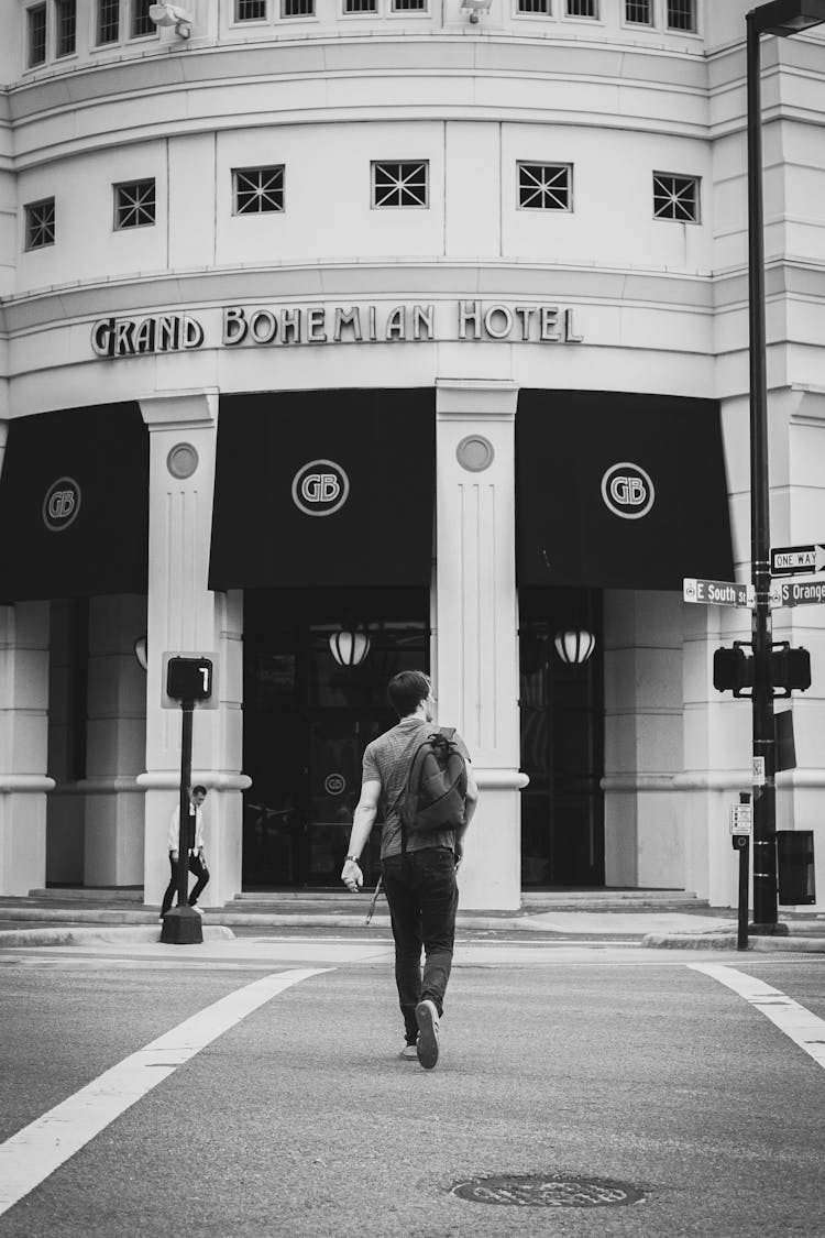 Man On Zebra Crossing In Front Of Hotel