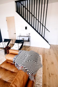 Stylish contemporary living room featuring a tan leather sofa and geometric decor.