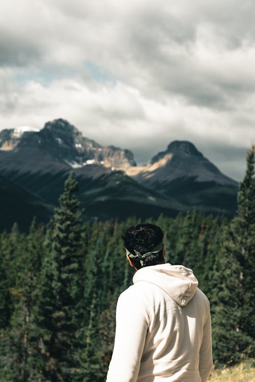 Man Looking at a View of Snowcapped Mountains in the Distance