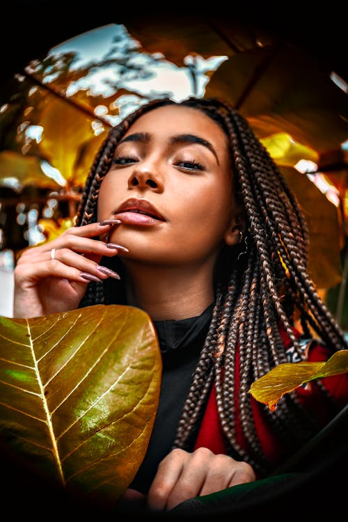 Woman in Braided Hair Near Leaves