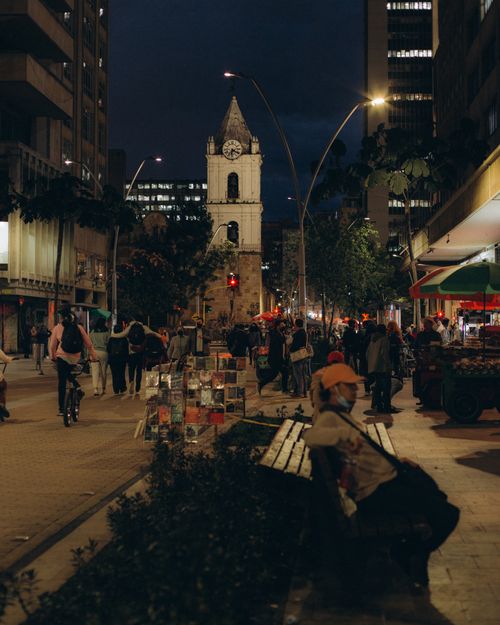 Free A lively pedestrian area in a city at night with a mix of people and architecture. Stock Photo