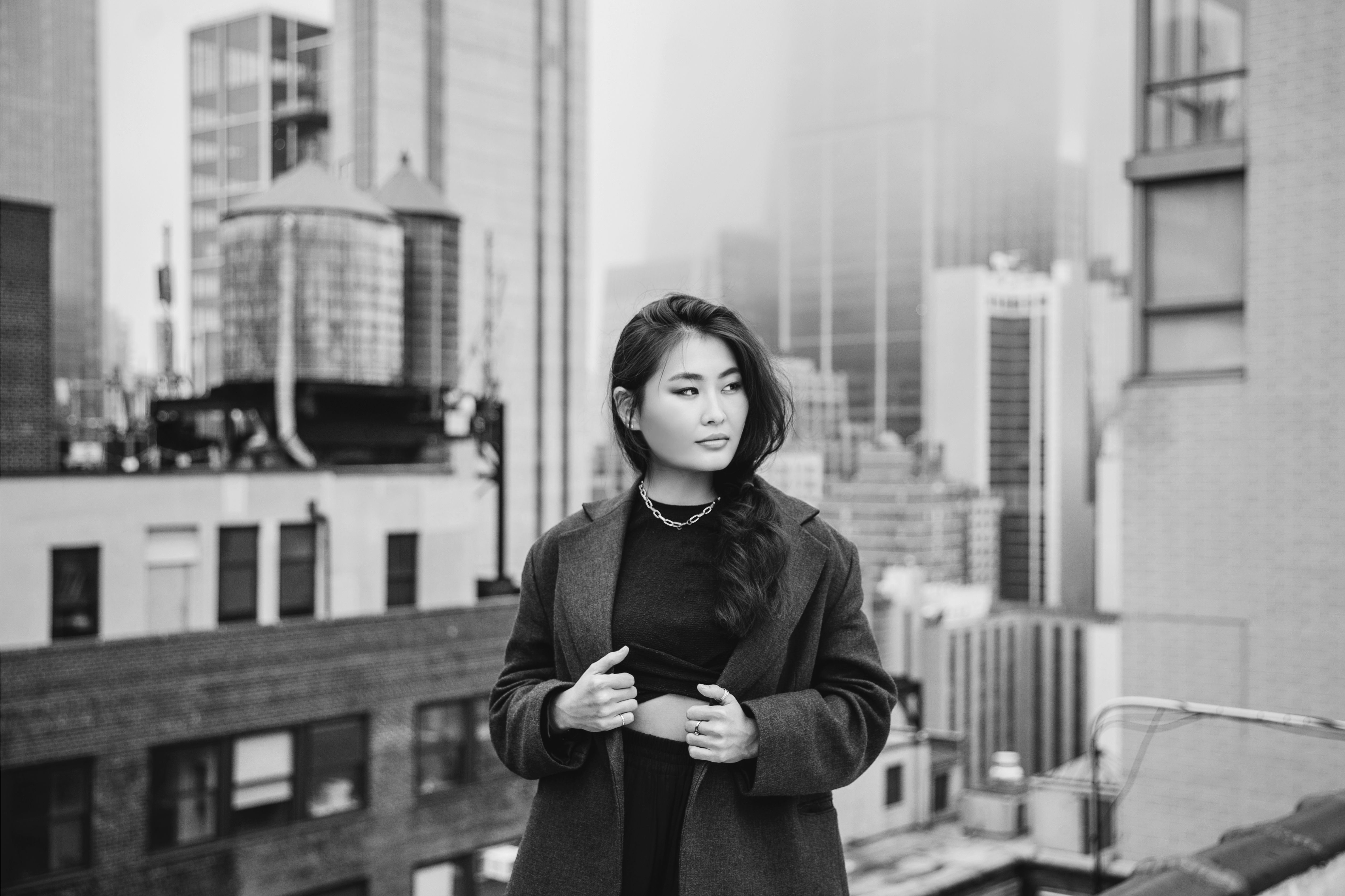 a woman in gray blazer standing on the rooftop