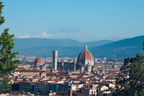 Free A captivating view of Florence's skyline featuring the iconic Cathedral dome against a mountainous backdrop. Stock Photo