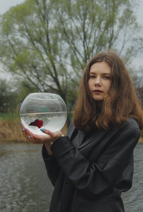 Photo of a Girl Holding a Fishbowl 
