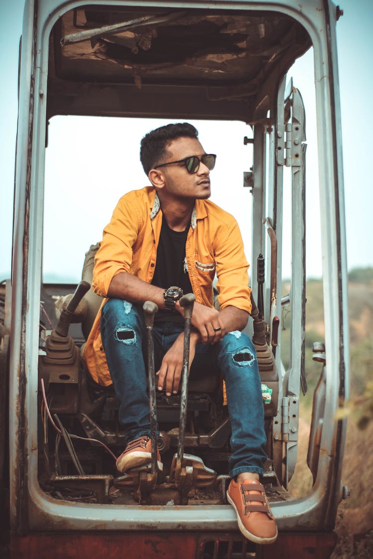 A Young Man Sitting Inside The Tractor Cab