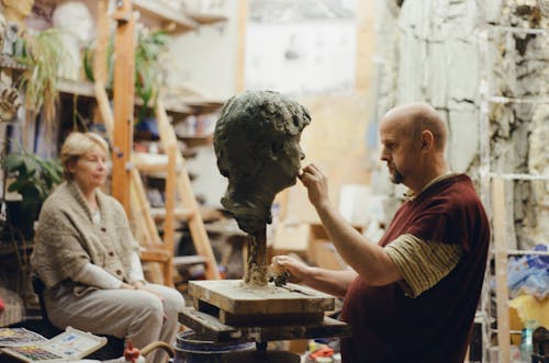Man Sculpting Face of Woman