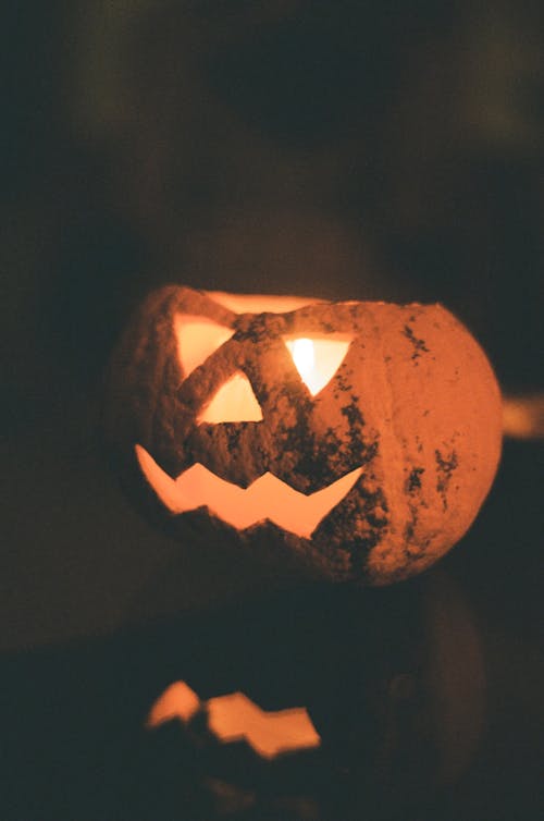 Jack O Lantern With Light on a Black Surface