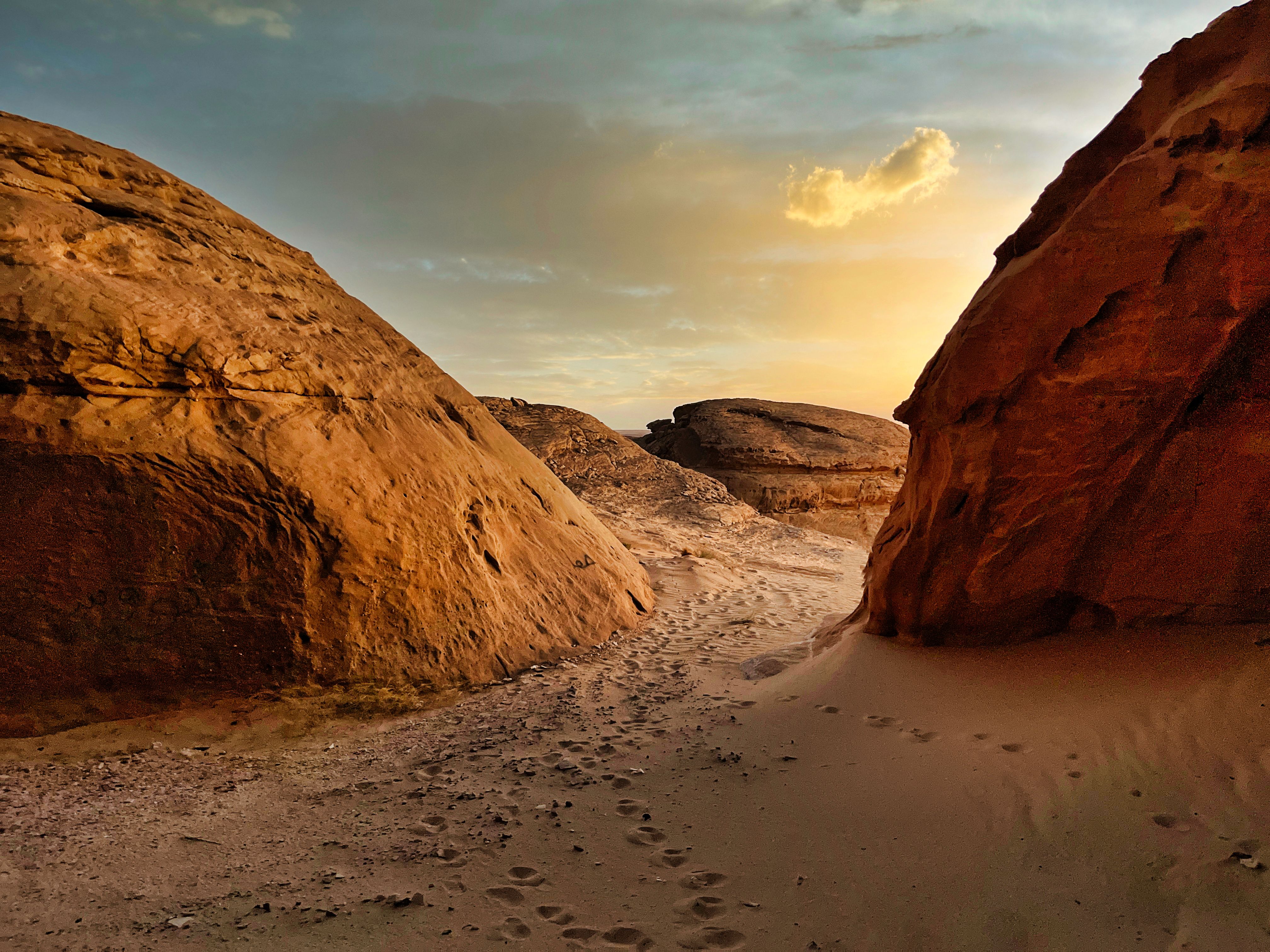 Captivating rock formations and sandy footpath at sunset in Nu'aymin, Hail Province.