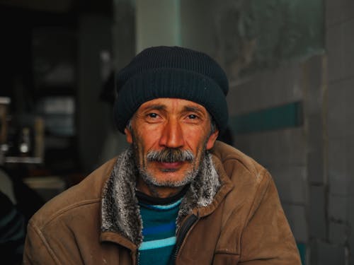 An Elderly Man Wearing a Beanie and a Jacket 