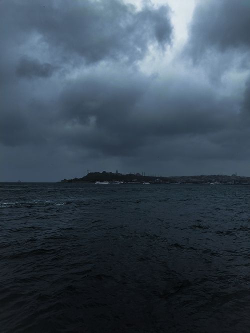 Free Dark, dramatic clouds loom over a stormy sea, creating a moody coastal scene. Stock Photo