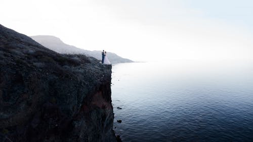 Free Portrait of Bride and Groom on Edge of Cliff Stock Photo