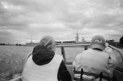 Grayscale Photo of Two People Riding a Boat on the Sea