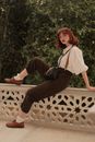 Woman in White Shirt and Brown Pants Sitting on Brown Wooden Bench