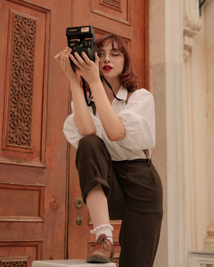 Retro Style Portrait Of Woman Taking Picture With Old Camera
