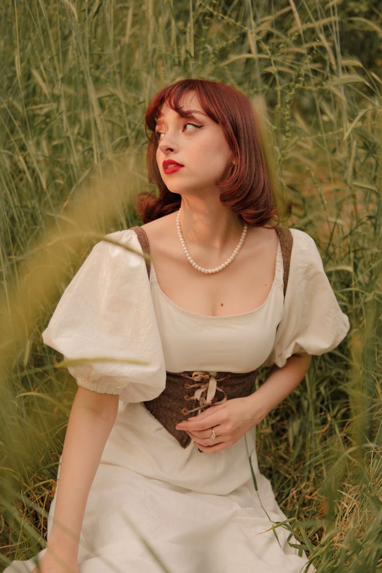 Portrait Of Woman Sitting In Meadow