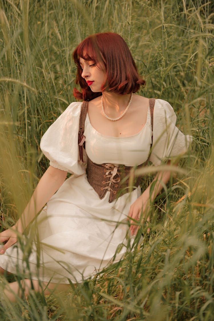 Portrait Of Woman Sitting In Meadow