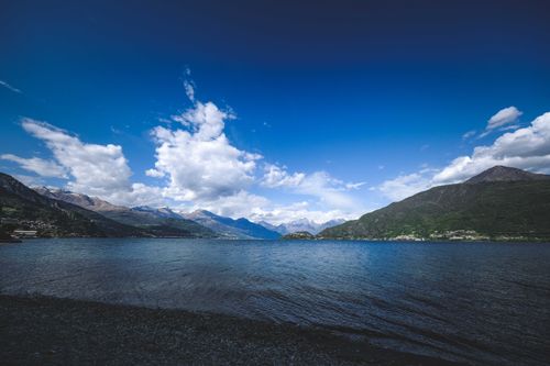Free A serene view of a mountain lake with a cloudy sky, perfect for nature lovers. Stock Photo