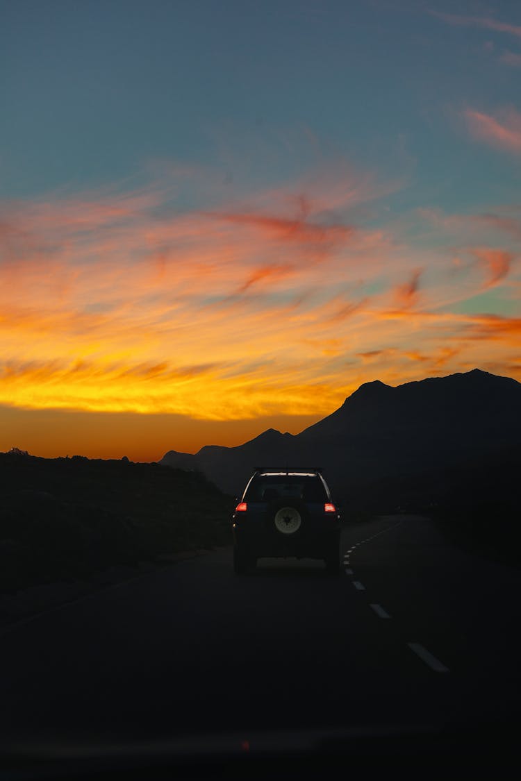 Car Driving On Road On Sunset