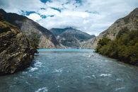 Green Trees Near Body of Water Under White Clouds and Blue Sky