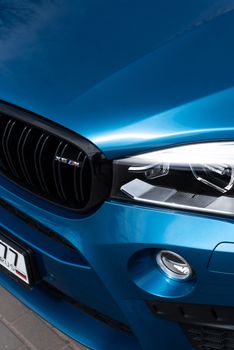 Detailed close-up of a luxury blue car front showcasing its design and elegance.