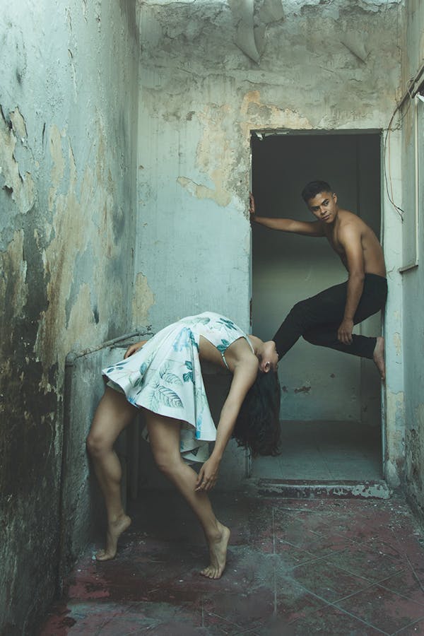 Barefoot Girl in Dress Tilting Backwards and Boy Exercising in Door