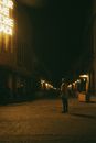 Man Standing in Street Before Theatre at Night