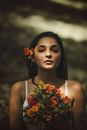 Brunette Young Woman with Orange Flower in Hair and Eye Makeup
