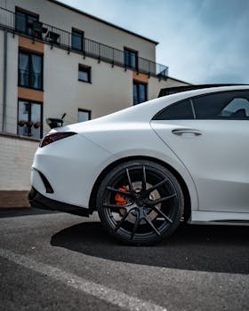 Close-up of a stylish white luxury car parked outdoors in a city setting.