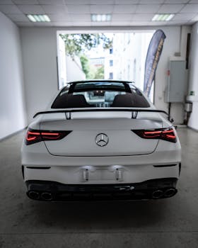 Rear view of a sleek white luxury car parked indoors, symbolizing elegance and sophistication.