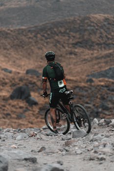 Cyclist riding a mountain bike on rough terrain in Mexico, showcasing adventure and endurance.