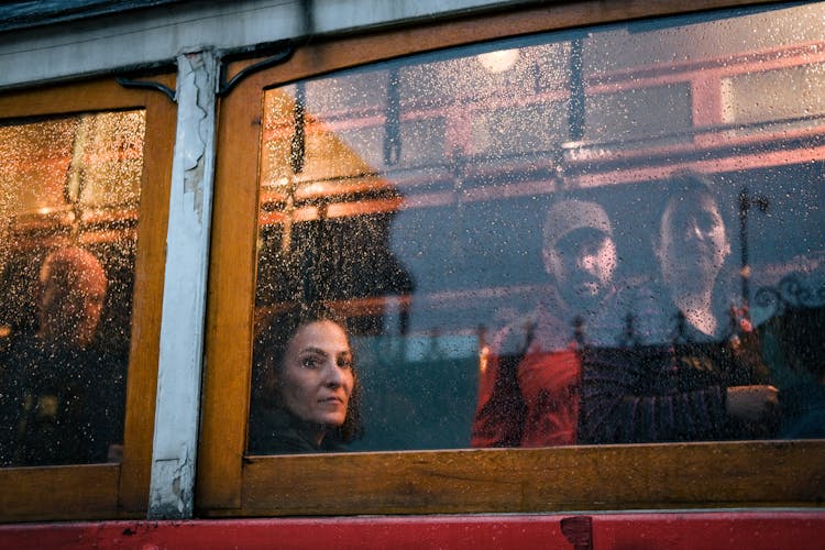 People Looking Out Of The Window On A Rainy Day