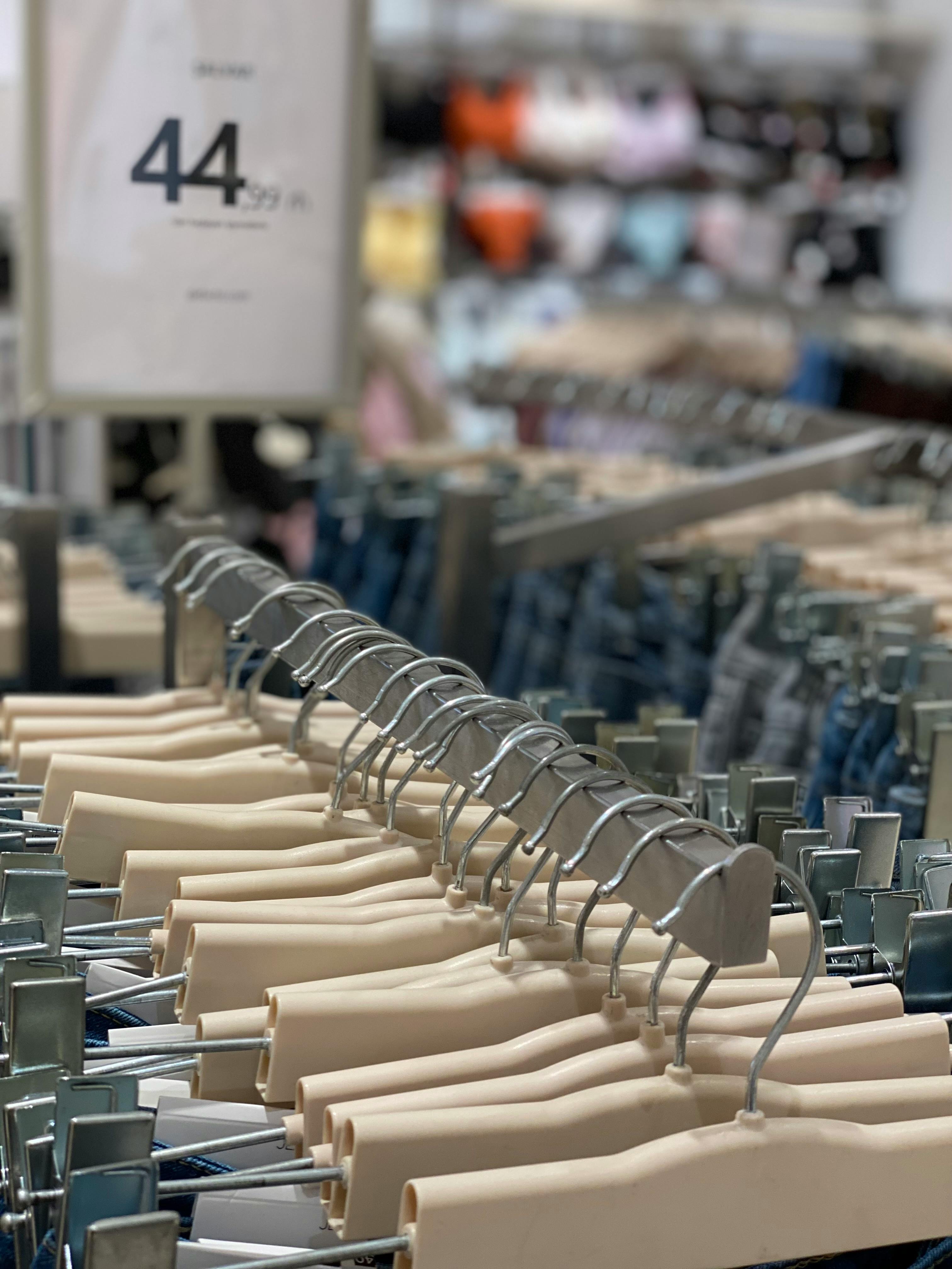 clothes in hangers hanging on racks