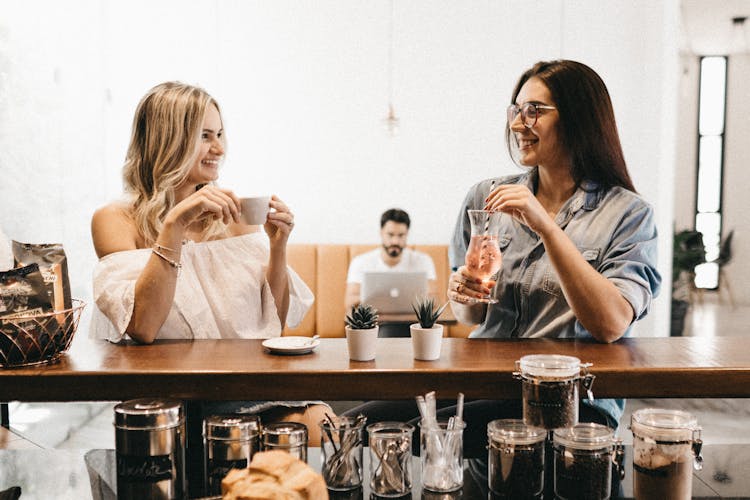 Women Sitting At Cafe Enjoying Coffee