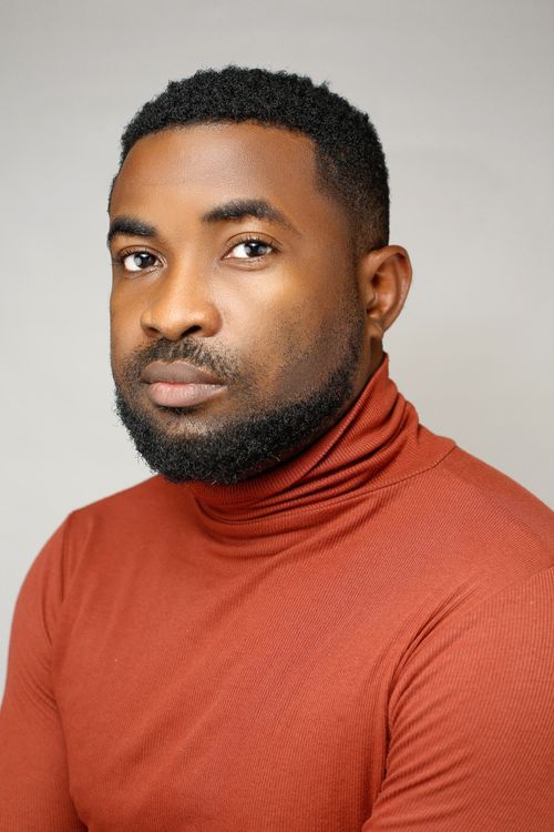 Free Professional headshot of a young man with a beard in a red turtleneck against a light background. Stock Photo