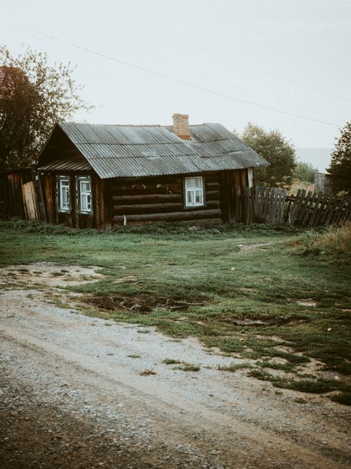 Free A peaceful rustic cabin situated in a tranquil countryside setting, surrounded by nature. Stock Photo