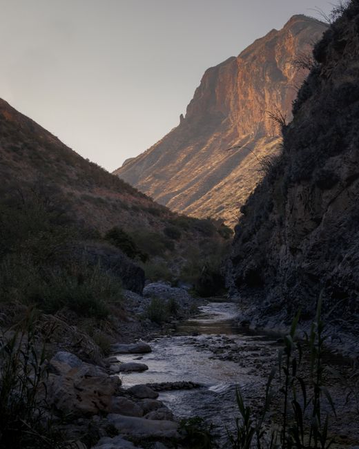 Explore the rugged beauty of Cadereyta's rocky gorge, with a flowing river and majestic mountains in the background.