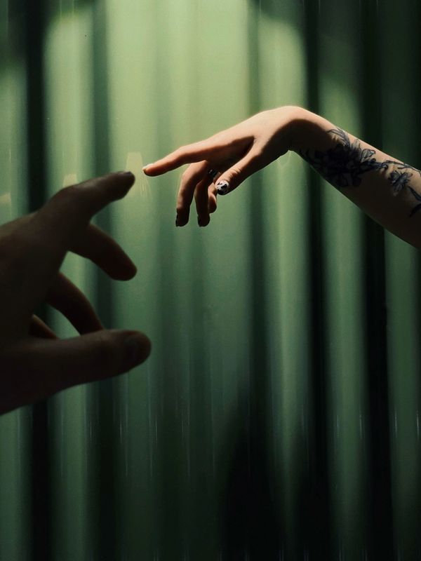 Two hands reaching toward each other