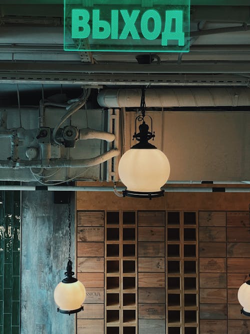 A Green Signage Above a White Pendant Lamp 