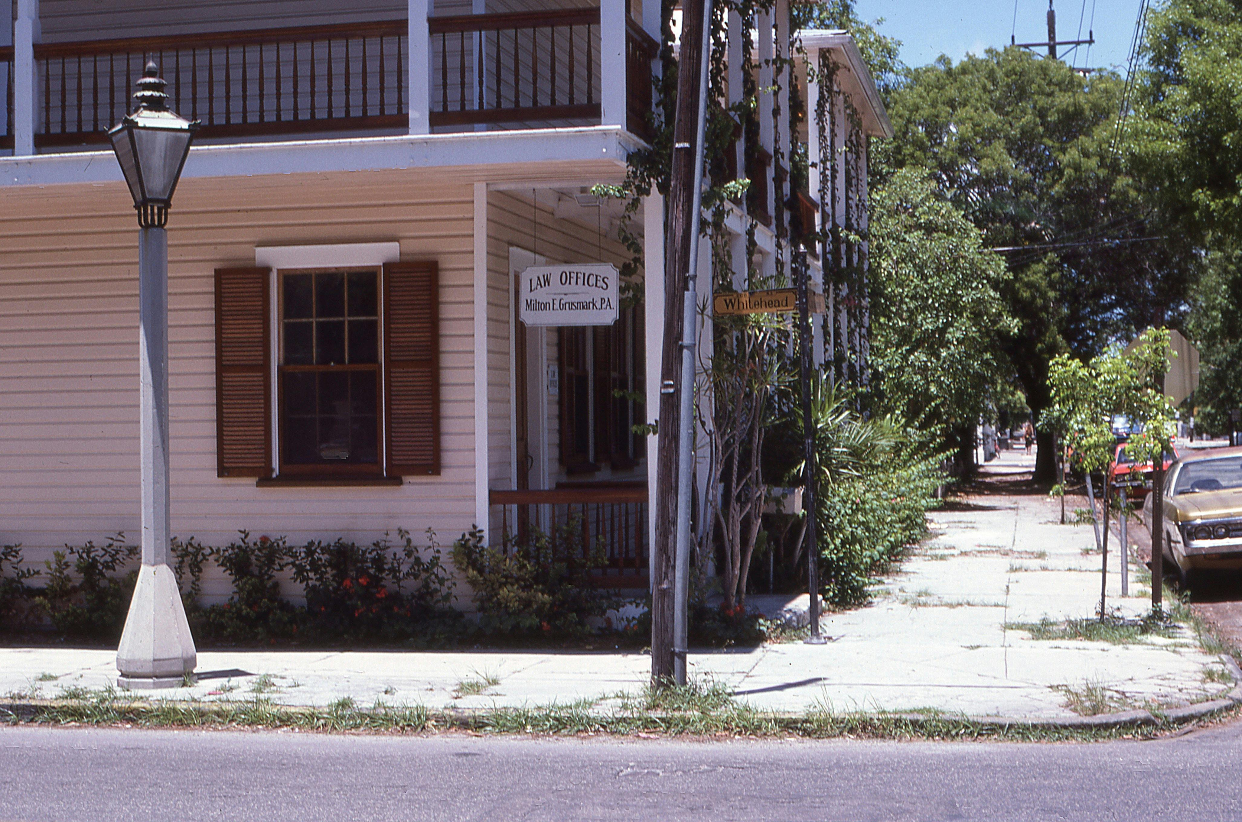 Free Charming historic law office with wooden shutters on a sunny corner with lush greenery. Stock Photo