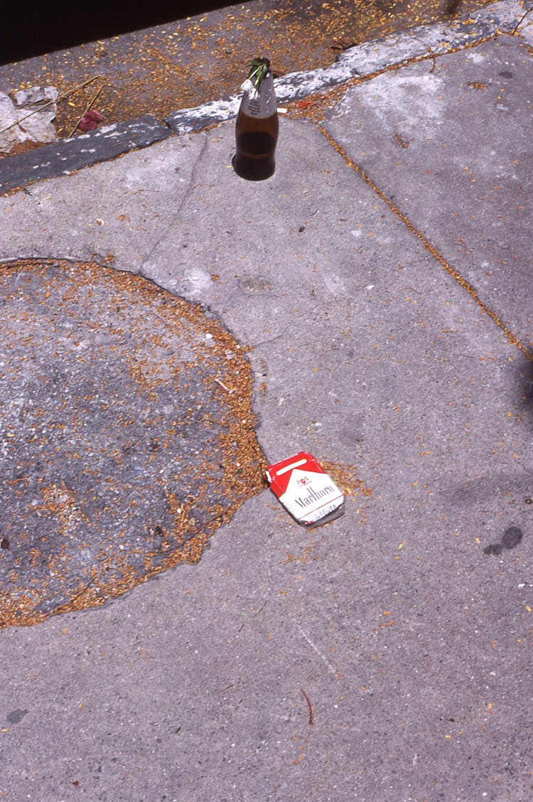 Pack Of Cigarette And Bottle Of Soda On The Ground