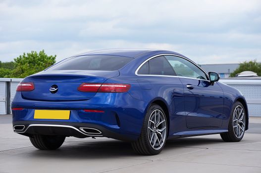 A luxurious midnight blue convertible parked in an outdoor setting, showcasing elegance and sophistication.