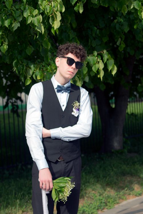 Free Stylish young man in sunglasses posing with bouquet under green tree in daylight. Stock Photo