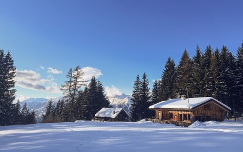 Free Charming wooden cabins nestled in a snowy forest landscape in Avelengo, Italy. Stock Photo