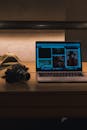 Digital Camera and Laptop on Wooden Surface