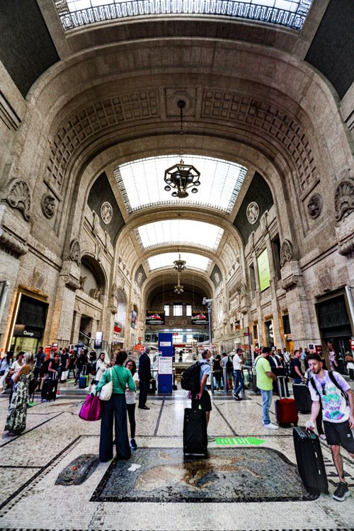 Free Bustling interior of Milan Central Station with travelers and architectural grandeur. Stock Photo