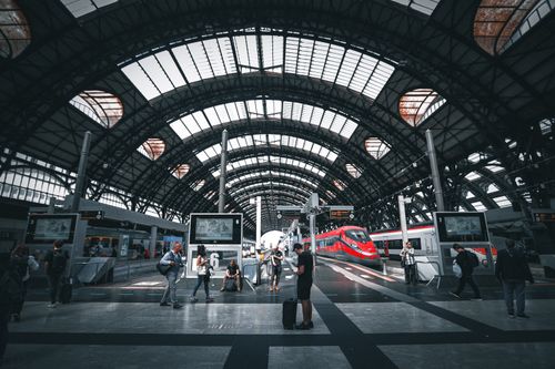 Free Commuters at Milano Central Station featuring modern trains under the iconic arched roof. Stock Photo