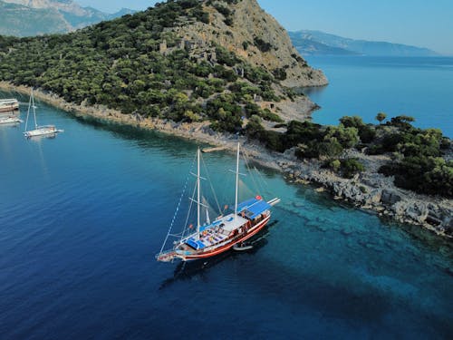 Aerial Photography of Boats on Blue Ocean near Island