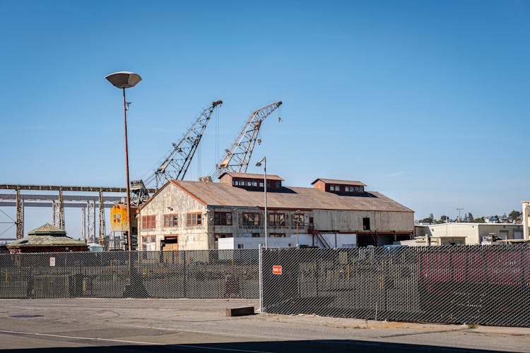 Brown Concrete Building Near Cranes